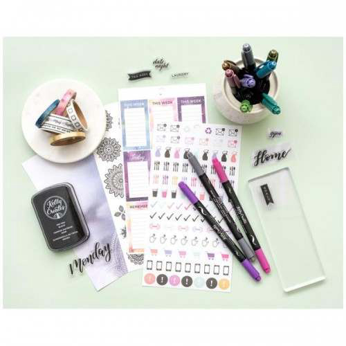 Assorted planner decorating accessories including washi, markers, stamps and stickers arranged on table