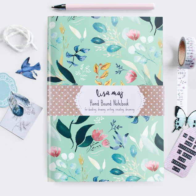 Pretty floral notebook on desk with papercraft accessories