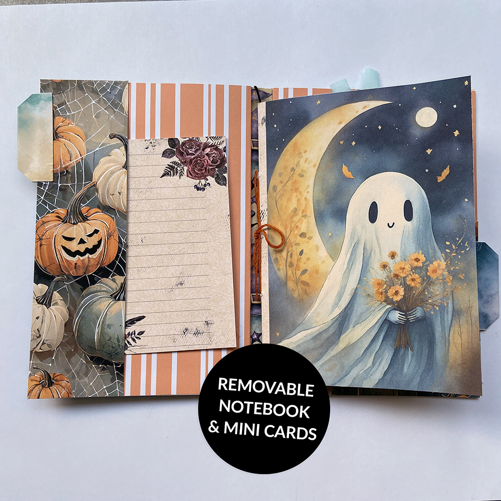 Handmade Halloween junk journal open to show inside pockets and a mini notebook with a whimsical ghost on the cover.