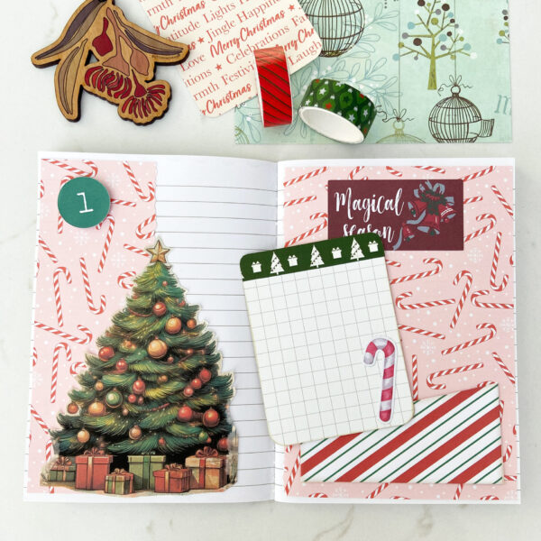 December Daily Junk Journal open to Day 1 decorated with candy canes paper, Christmas tree, pocket and journaling card.