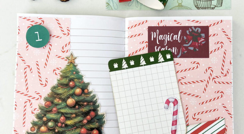 December Daily Junk Journal open to Day 1 decorated with candy canes paper, Christmas tree, pocket and journaling card.