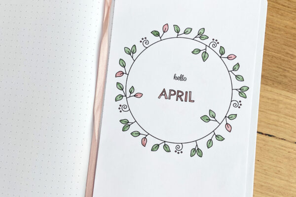 Printable April Monthly cover page featuring hand drawn wreath with little leaves and swirls, inside dot grid bullet journal
