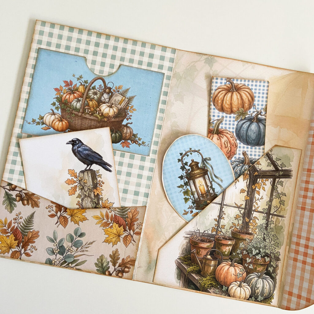 Inside the Pumpkin Conservatory Junk Journal folio, featruring warm creams, sage green, and dusty blue autumn colors. The folio has several pockets attached that are filled with autumn botanical cards and ephemera.