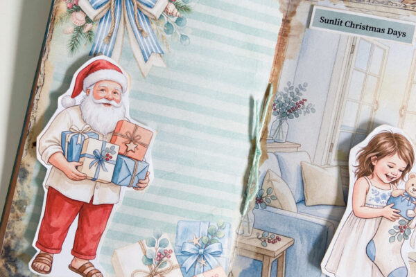 Coasta Christmas junk journal with Santa fussy cut holding presents and a little girl with a Christmas stocking